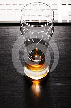 Drained glass of lager beer on table