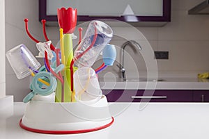 Drainer full of baby plastic tableware objects