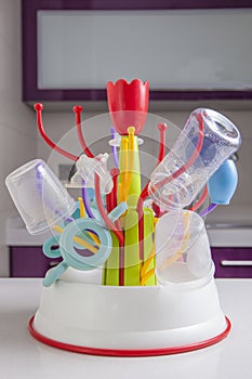 Drainer full of baby plastic tableware objects