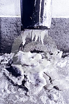 The drainpipes are covered with ice and snow. After a heavy snowstorm, the city is covered with snow and ice