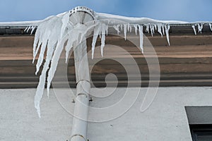 The drainpipes are covered with ice and snow. After a heavy snowstorm, the city is covered with snow and ice. There are many