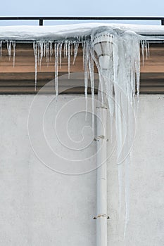 The drainpipes are covered with ice and snow. After a heavy snowstorm, the city is covered with snow and ice. There are many