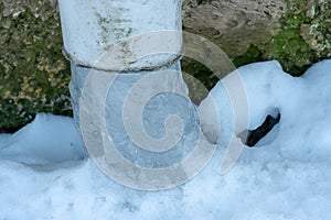 The drainpipes are covered with ice and snow. After a heavy snowstorm, the city is covered with snow and ice. There are many