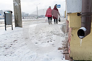 The drainpipes are covered with ice and snow. After a heavy snowstorm, the city is covered with snow and ice. There are many