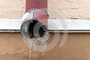 The drainpipes are covered with ice and snow. After a heavy snowstorm, the city is covered with snow and ice. There are many