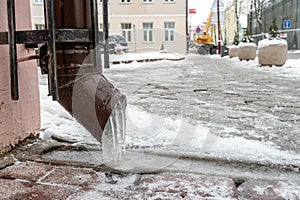 The drainpipes are covered with ice and snow. After a heavy snowstorm, the city is covered with snow and ice. There are many