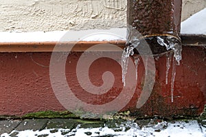 The drainpipes are covered with ice and snow. After a heavy snowstorm, the city is covered with snow and ice. There are many