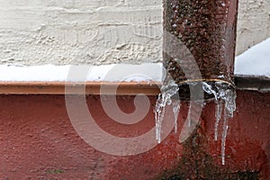 The drainpipes are covered with ice and snow. After a heavy snowstorm, the city is covered with snow and ice. There are many