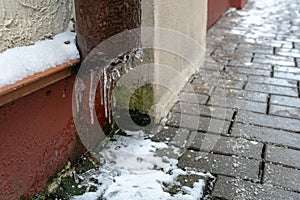 The drainpipes are covered with ice and snow. After a heavy snowstorm, the city is covered with snow and ice. There are many