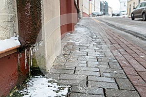 The drainpipes are covered with ice and snow. After a heavy snowstorm, the city is covered with snow and ice. There are many