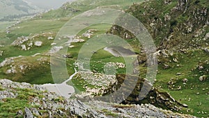 Dramatic aerial drone footage of the Romanian village with mountain lake on Transalpina road