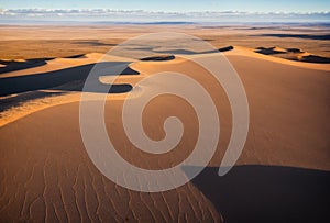 Dramatic aerial view of endless sandy desert dunes with cloud shadows. AI generated.