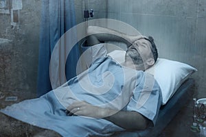 Dramatic artistic hospital portrait of attractive and scared man infected by covid19 -  adult male in face mask receiving
