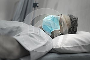 Dramatic artistic hospital portrait of attractive and scared man infected by covid19 -  adult male in face mask receiving