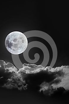 Dramatic atmosphere of bright and beautiful midnight full moon with clouds on peaceful dark night summer clear sky. Moon image