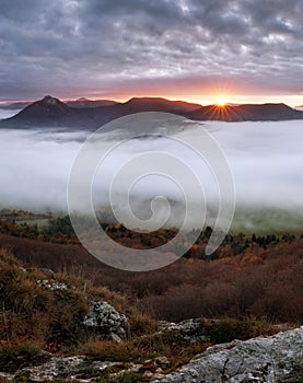 Dramatic autumn sunrise in mountain with red sky and clouds