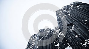 Dramatic basalt columns covered in winter snow
