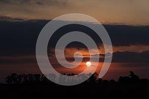 Dramatic and beautiful sunset, cloudy sky with parts of intense orange color