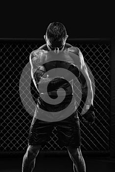 The dramatic black white image of the MMA fighter. Photography in a real octagon. Brutal fighter