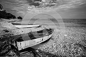 Dramatic black and white image of wooden fishing boats on the caribbean coast in Los Patos, dominican republic.