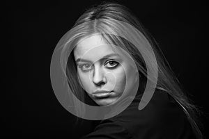 Dramatic black and white portrait of a beautiful woman on a dark background