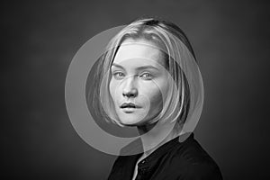 Dramatic black and white portrait of a beautiful woman on a dark background