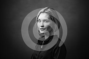 Dramatic black and white portrait of a beautiful woman on a dark background