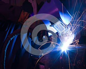 Dramatic blue-lit MIG welding close