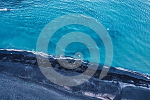 Dramatic blue sea with ripple wave erosion textured on black sand beach