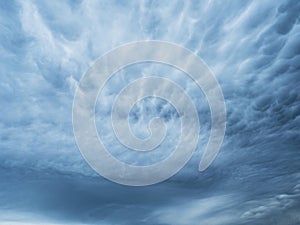 Dramatic blue sky with clouds. Spooky abstract background pattern texture.