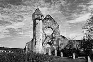 Dramatic church ruins in black and white, with a few tombstones in front. Carta monastery is a former Benedictine church.