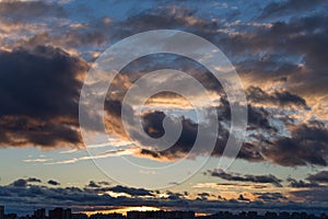 Dramatic cityscape and cloudscape in sunset time with heavy clouds on sky