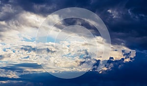 Dramatic cloud sky with dark rain clouds and sun before or after thunderstorm.
