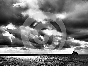 Dramatic clouds, black and white of offshore oil platform