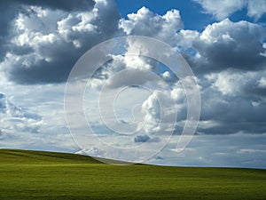 Dramatic clouds over a green field