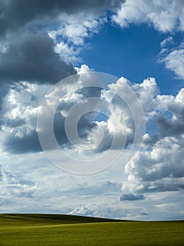 Dramatic clouds over a green field