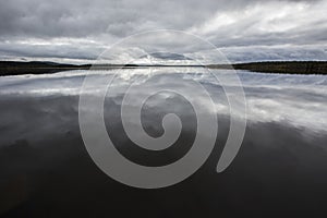 Dramatic clouds reflection in Muonio Lake, Lapland, Northern Finland