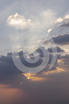 Dramatic clouds and shining form an interesting light pattern against the sky background