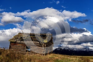 Dramatic clouds in the sky and mountain with a log cabin