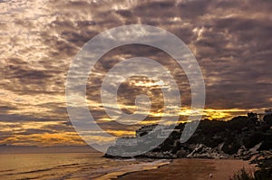 Dramatic cloudscape over beach at sunset.