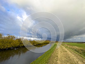 Dramatic cloudscape over Wieprza river dike in Poland