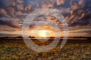 Dramatic cloudscape at sunset over meadow