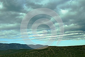 Dramatic cloudy sky with light horizon over mountains