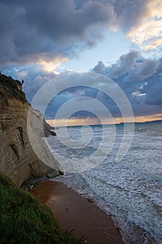 Dramatic coastal cliffs meet a turbulent sea under a brooding sky