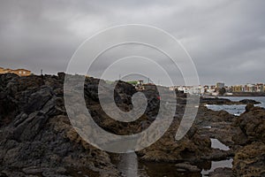 Dramatic coastal scene in Gran Canaria with waves crashing against dark volcanic rocks. El Bufadero photo