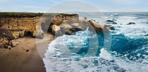 Dramatic coastline landscape, pano. Rocky Cliffs, Pacific Ocean, and native plants on the beach, Montana de Oro State Park,