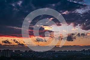 Dramatic colorful autumn clouds at sky over city at sunset, beautiful nature landscape panorama