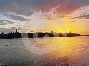 Dramatic colorful sunset over Dnipro river in Kiev, Ukraine. Historical sights of Ukraine. Beautiful scenic view of Kyiv. Sunset