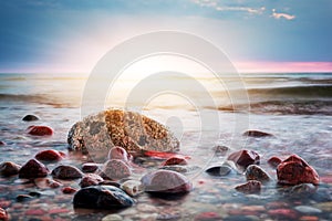 Dramatic colorful sunset on a rocky beach. Baltic sea
