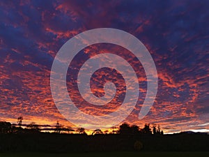 A dramatic and colourful fire sky sunset lighting up the low clouds and turning them a fiery red